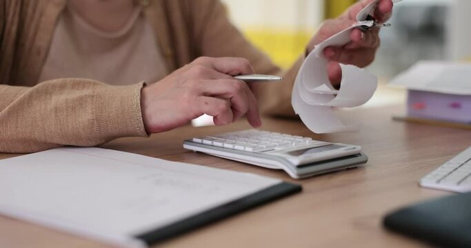 Senior lady writes calculation in notebook with accounts. Counting purchases and planning for retirement