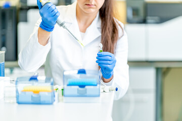 dropper dosing of chemical samples into flasks for research in a scientific laboratory