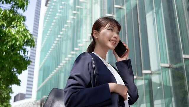 笑顔で電話をする日本人ビジネスウーマン