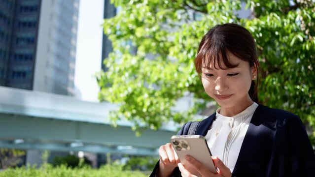 スマホを操作する日本人ビジネスウーマン