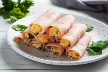 Ham and cheese rolls on a plate. Delicious appetizer meat carbonate and cream cheese.