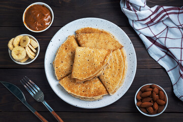 Pancakes with chocolate banana filling. Wooden rustic table, sweet delicious dessert.