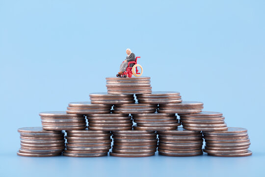 Miniature creative elderly at the top of the coin pyramid