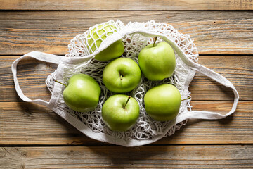 Close-up, green apples in a mesh shopping bag, top view.