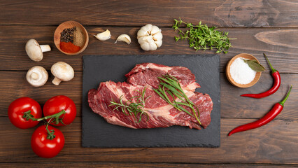 Raw beef steak on wooden table top. Healthy food concept. beef cut and spices for cooking bbq sauce