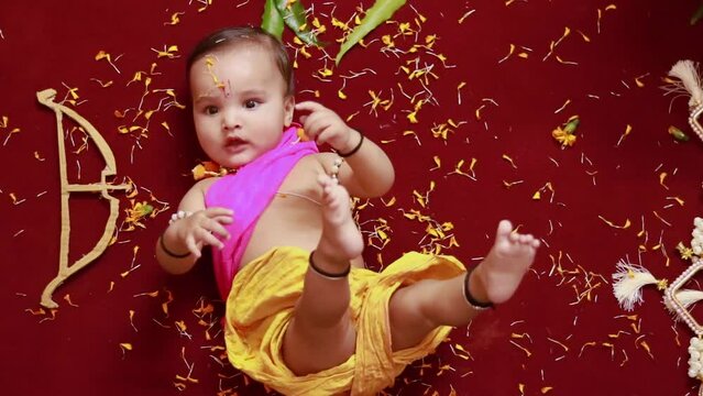 cute Indian boy dresses as lord rama with bow and flowers from top angle