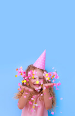 birthday little girl laughs rejoices throws confetti on blue background