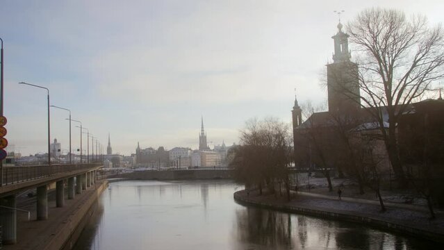 Video footage shows Stockholm's historically significant buildings above the Klara sj&ouml; on a sunny winter day with people and cars moving in the background. Bustling city. Perfect for news, ads,