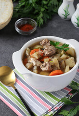 Pichelsteiner, German stew or thick soup with meat and vegetables in white bowl