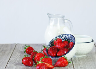 Fresh sweet strawberries and jug of milk