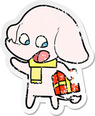 distressed sticker of a cute cartoon elephant with christmas present