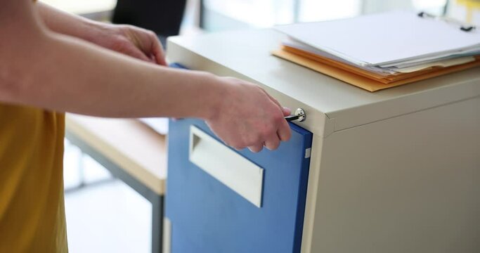 Woman manager secretary closes drawer with key with documents. Document security in business