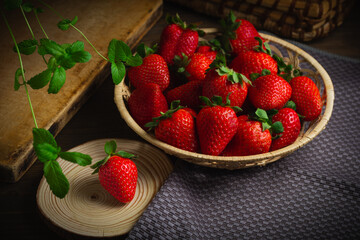 Strawberry basket on the wood background in low key