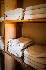 Neatly Folded 1950s Style White Blankets On Cupboard Shelves In An Abandonned Asylum