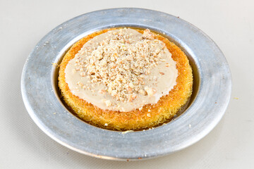 Pistachio kadayif on a plate. Turkish Dessert Kadayif with pistachio powder. Kunefe. Local name burma kadayif