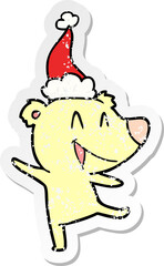 laughing bear hand drawn distressed sticker cartoon of a wearing santa hat