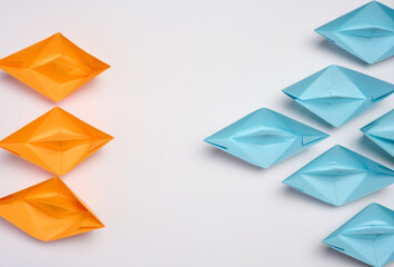 Two groups of paper boats facing each other, a concept of confrontation, top view