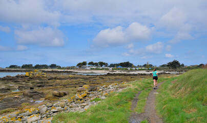 Une jeune femme qui pratique le footing sur le GR34 en Bretagne