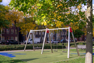 Obraz na płótnie Canvas Suspended modern swing on the playground. Soft lawn covering