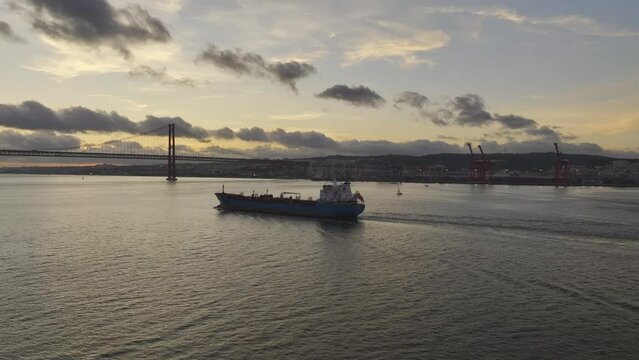 Drone footage of tanker ship heading under the bridge in Lisbon.