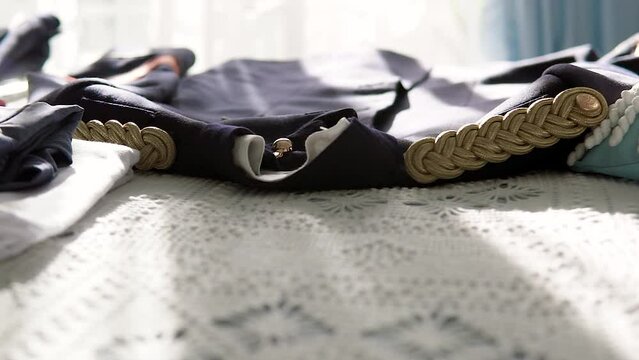 Shot Of Military Uniform Clothing Placed On Bed Under Sunlight 