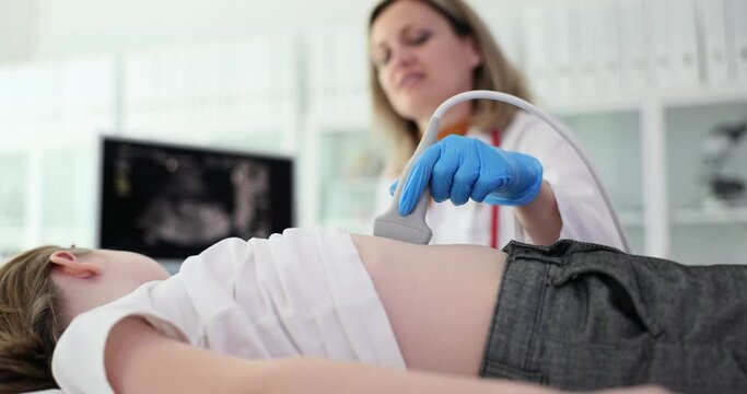 Doctor makes ultrasound of abdomen and internal organs of child. Abdominal pain causes symptoms and diagnosis