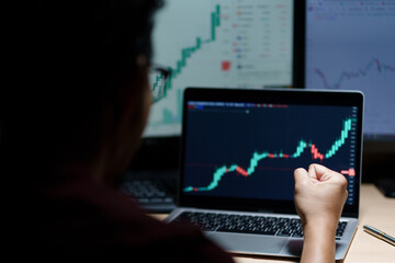 Successful Businessman Sitting at Desk Using Laptop Computer, Celebrate Success. Entrepreneur in Suit working with Stock Market App Smiles, Happy Victory. Motion Blur Background.