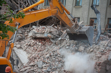 Demolition of building. Excavator breaks old house. Freeing up space for construction of new building