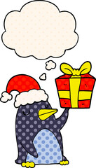 cartoon penguin with christmas present with thought bubble in comic book style