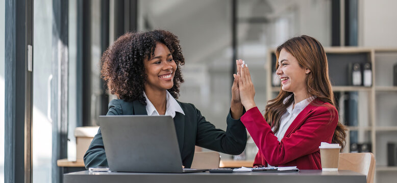 Two business people talk project strategy at office meeting room. Businessman discuss project planning with colleague at modern workplace while having conversation and advice on financial data report.