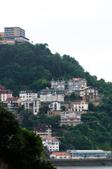 Naklejka premium SAN SEBASTIAN, Spain July 08 2022: View of Igeldo Mountain. Beautiful urbanisation with sensational view all over the La Concha Bay. Igeldoko Dorrea tower in left corner. Vertical photo.