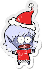 hand drawn distressed sticker cartoon of a shocked elf girl wearing santa hat