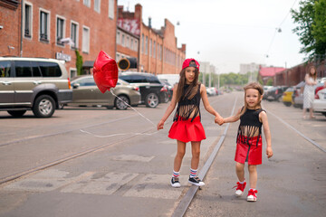 Children cross the road with tram tracks in an unidentified place. Insurance of children's health...