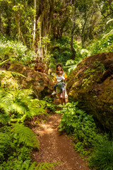 A young woman trekking on a path in La Llania on El Hierro, Canary Islands. lush green landscape