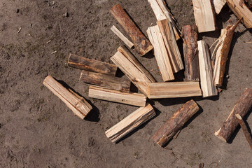 Firewood scattered on the ground. Background of firewood. Preparation of firewood for the winter. 
