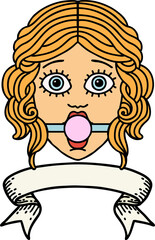 traditional tattoo with banner of female face wearing a ball gag