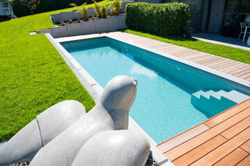Spatz aus Beton als Gartengestaltung an einem Pool