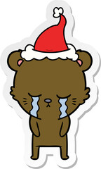 crying hand drawn sticker cartoon of a bear wearing santa hat