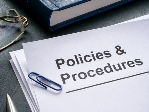 Documents about policies and procedures are on the table.