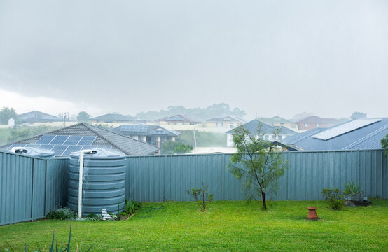 Heavy rainfall in backyard with water overflowing from tank