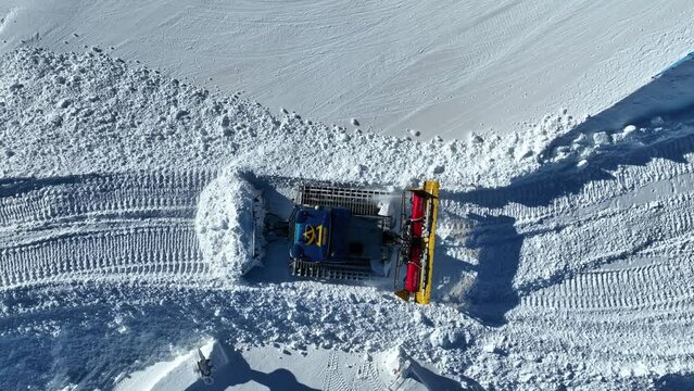 Top Down Aerial View of Snow Groomer in Ski Resort, Working on Sunny Winter Day