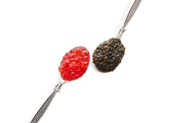 Two vintage silver spoons with black and red caviar isolated on white background. Top view, flat lay, copy space.                               .