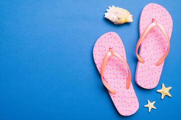 Flat lay composition with flip flops and seashell on colored background. Space for text top view