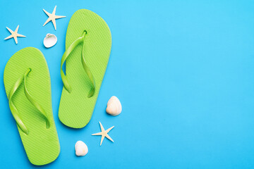 Flat lay composition with flip flops and seashell on colored background. Space for text top view