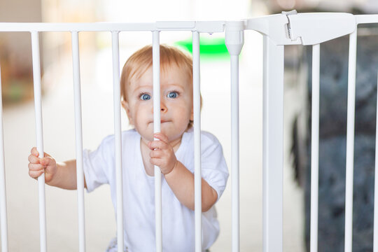 Infant safety with young child standing at baby gate