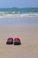 the black and red crooks sleepers left on the beach with waves in the background