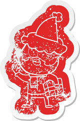 quirky cartoon distressed sticker of a bearded man with present wearing santa hat