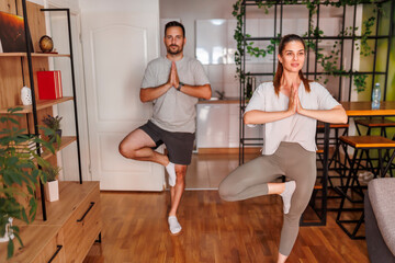 Couple doing yoga as home workout routine