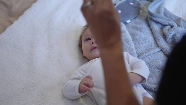 A little baby following the sound of a rattle