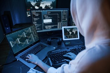 Phishing attack. Young professional female hacker is indoors by computer with lot of information on...